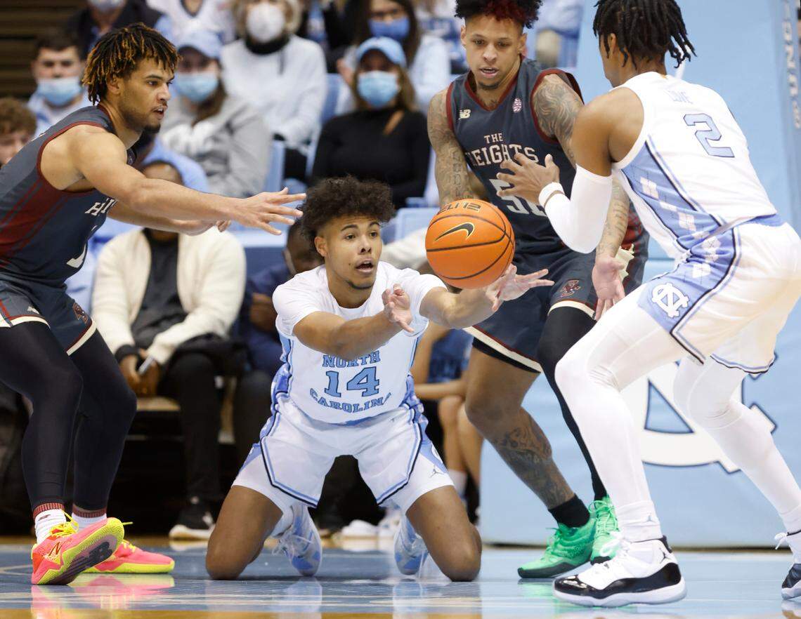 North Carolina’s Puff Johnson (14) passes to Caleb Love (2) as Boston College’s T.J. Bickerstaff (1), left, and Brevin Galloway (51) watch during the second half of UNC’s 58-47 victory over Boston College at the Smith Center in Chapel Hill, N.C., Wednesday, Jan. 26, 2022.