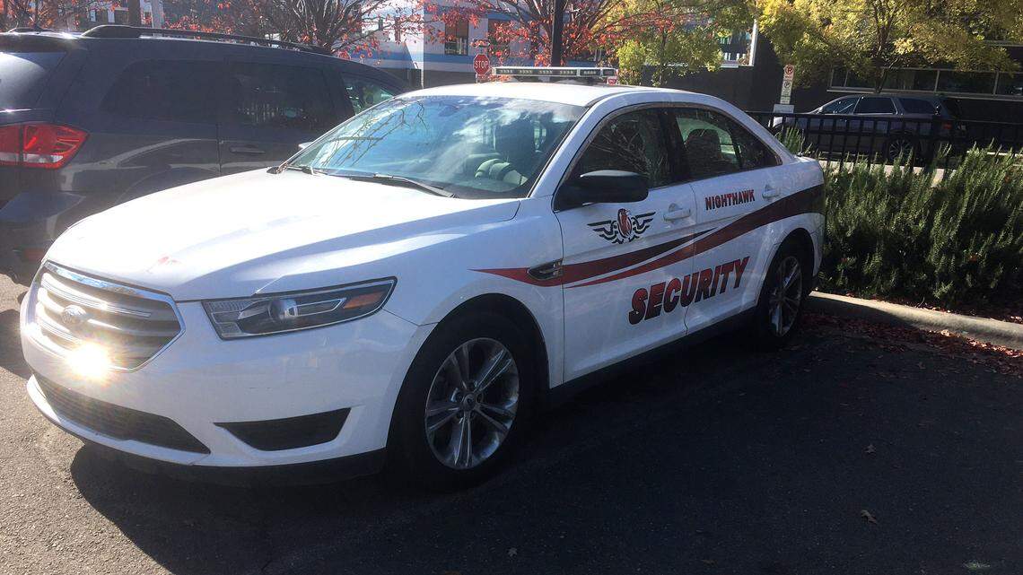 A Night Hawk Security & Consulting patrol car sits across from the Durham County Department of Public Health. The company has a multi-million dollar contract to provide security to county buildings and parking areas, including the courthouse and jail.