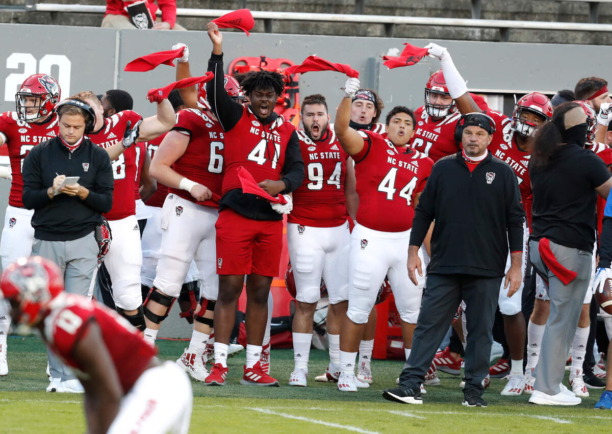 The N.C. State sidelines cheer on the defense during the second half of N.C. State’s 31-20 victory over Duke at Carter-Finley Stadium in Raleigh, N.C., Saturday, Oct. 17, 2020.