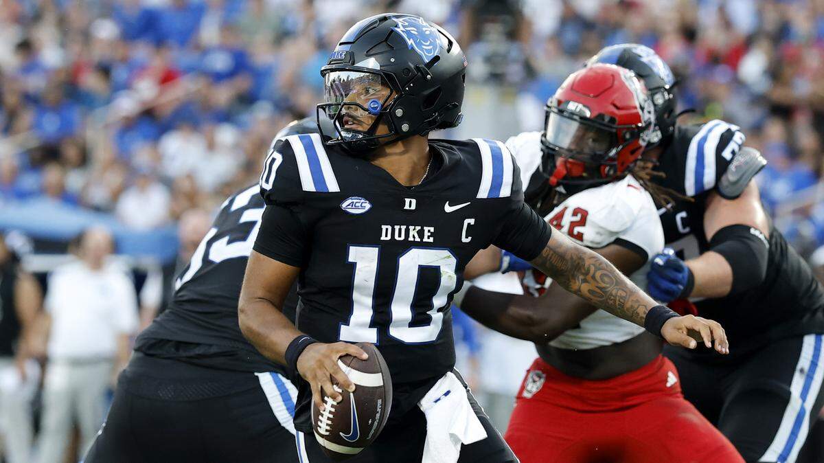 Duke quarterback Darian Mensah (10) escapes the pressure by N.C. State’s Kevon Carter (42) during the second half of Duke’s 45-33 victory over N.C. State at Wallace Wade Stadium in Durham, N.C., Sat. Sept. 20, 2025
