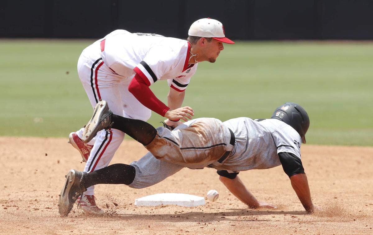 Campbell’s Matthew Barefoot (28) slides safely into second and advances to third after knocking the ball from N.C. State’s Will Wilson (8) in the fourth inning during N.C. State’s game against Campbell in the Greenville Regional at Clark-LeClair Stadium in Greenville, N.C., Friday, May 31, 2019. Wilson was charged with an error.