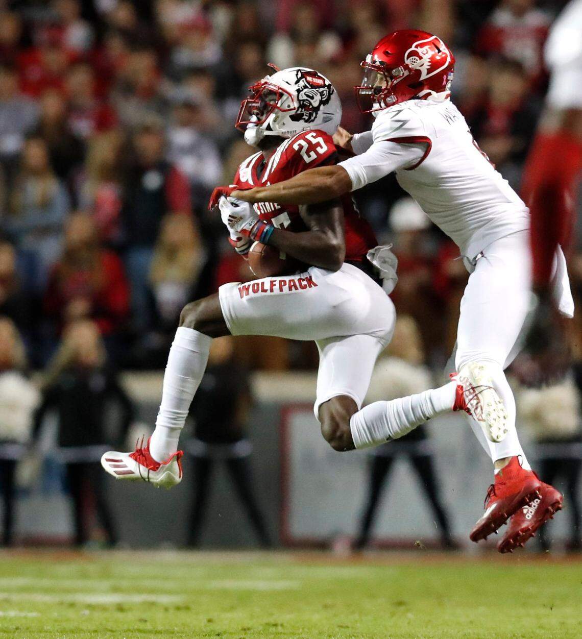 N.C. State cornerback Shyheim Battle (25) intercepts the ball intended for Louisville wide receiver Jordan Watkins (1) during the first half of N.C. States game against Louisville at Carter-Finley Stadium in Raleigh, N.C., Saturday, October 30, 2021.