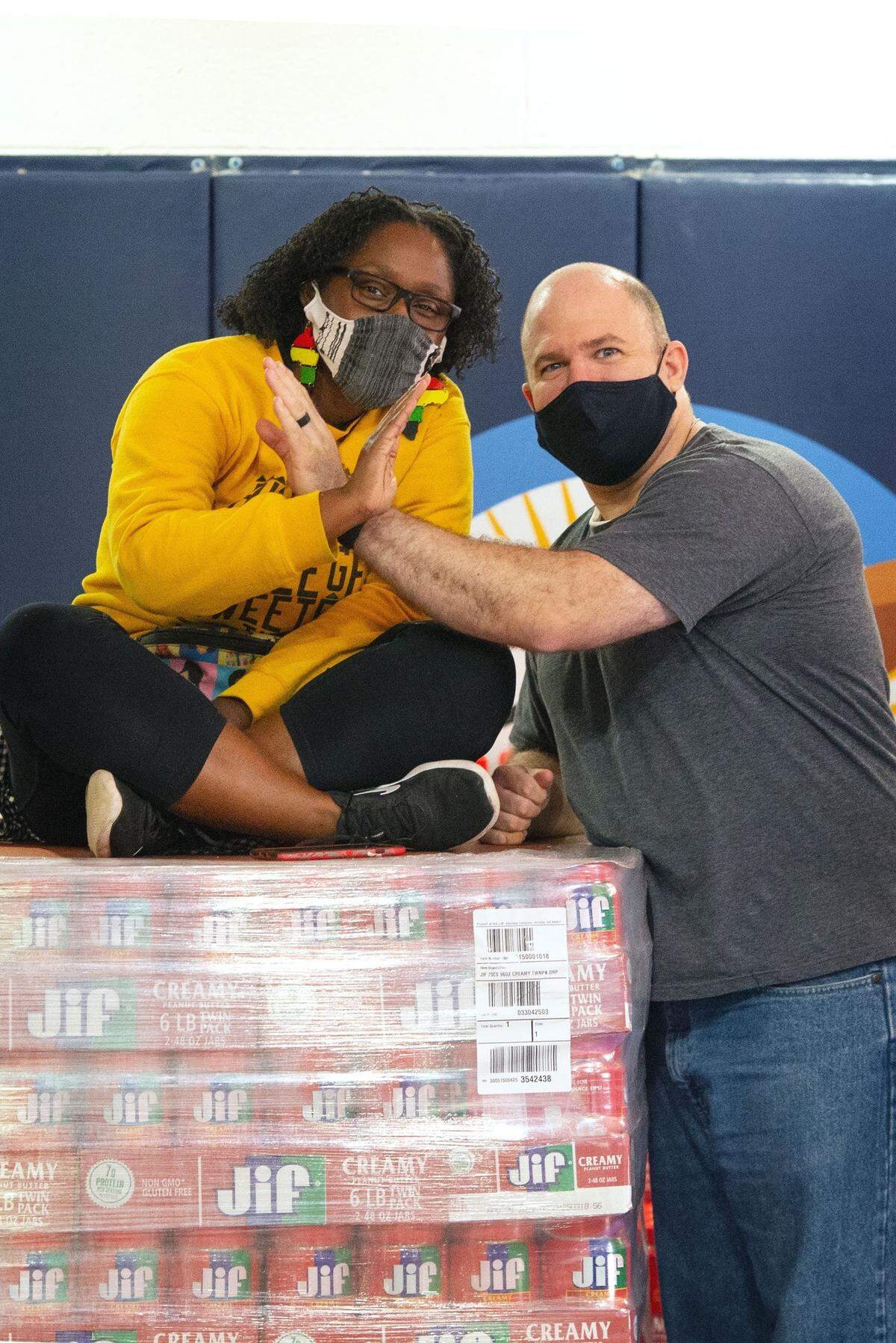 Turquoise Lejune Parker and T. Greg Doucette pictured over top of every jar of Jiff peanut butter they purchased from a Durham Costco in 2020.