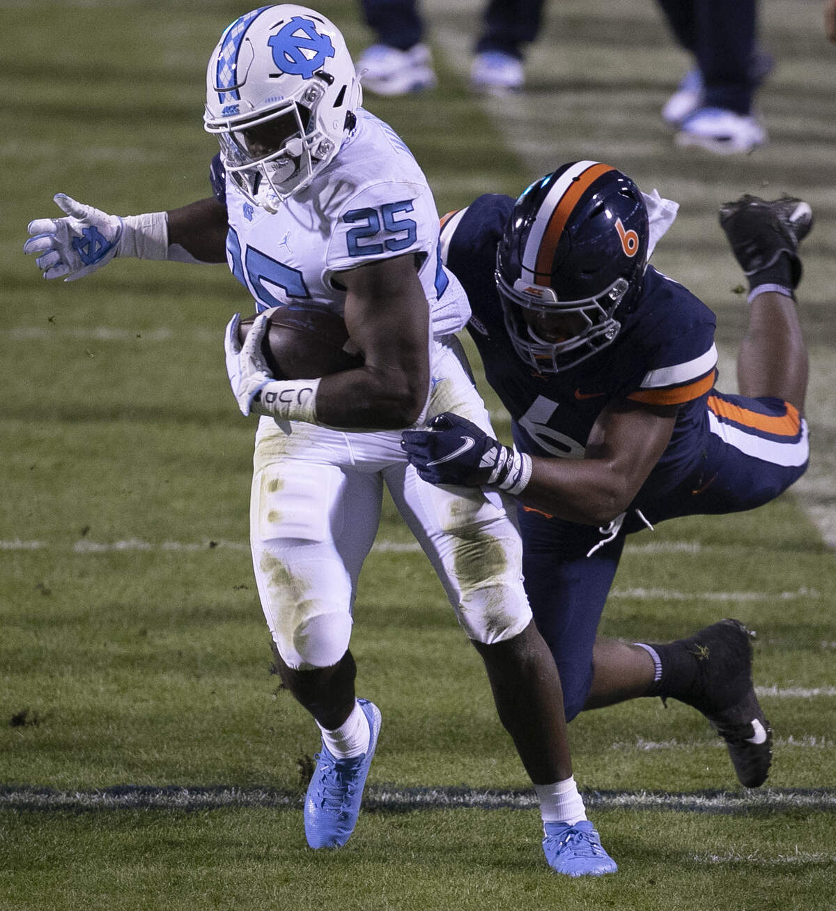 Virginia’s Nick Jackson (6) works to stop North Carolina’s Javonte Williams (25) after a nine-gain in the first quarter on Saturday, October 31, 2020 at Scott Stadium in Charlottesville, Va.
