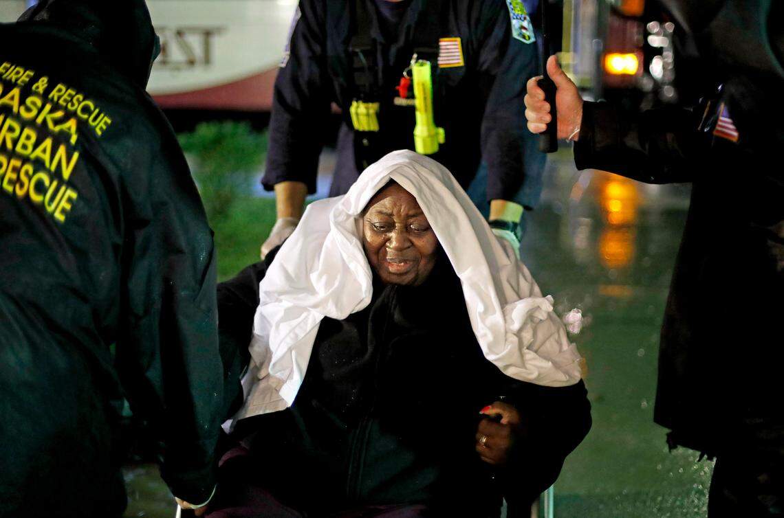 Ernestine Crumpler, 80, is helped by members of the Nebraska Task Force 1 urban search and rescue team as they evacuate an assisted living facility to a church as a precaution against potential flooding the city could see from tropical storm Florence in Fayetteville, N.C., Saturday, Sept. 15, 2018. 