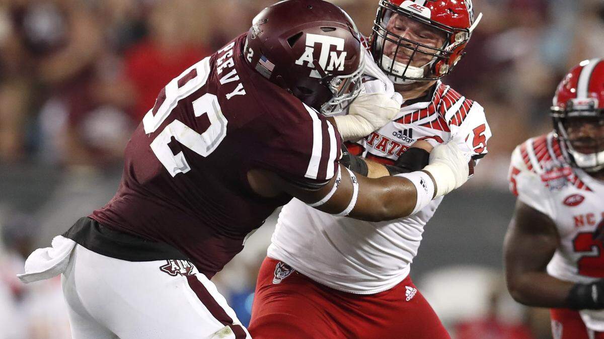 N.C. State center Garrett Bradbury (65) blocks Texas A&M defensive lineman Jayden Peevy (92) during the first half of N.C. State’s game against Texas A&M in the TaxSlayer Gator Bowl at TIAA Bank Field in Jacksonville, Fla., Monday, Dec. 31, 2018.