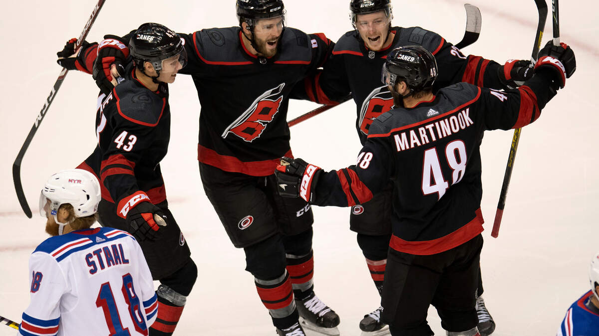 New York Rangers defenseman Marc Staal (18) skates away as Carolina Hurricanes left wing Jordan Martinook (48) is congratulated on his goal by teammates Morgan Geekie (43), Joel Edmundson (6) and Brock McGinn (23) during the second period of an NHL Stanley Cup playoff hockey game in Toronto, Monday, Aug. 3, 2020. (Frank Gunn/The Canadian Press via AP)