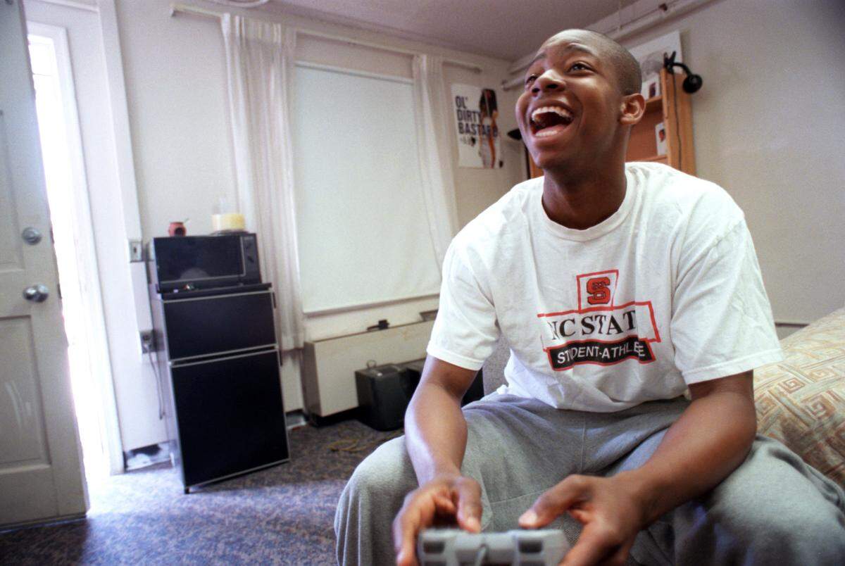 Justin Gainey takes a break from the books to play a little video game basketball at his dorm room at Avent Ferry Complex in 2000.