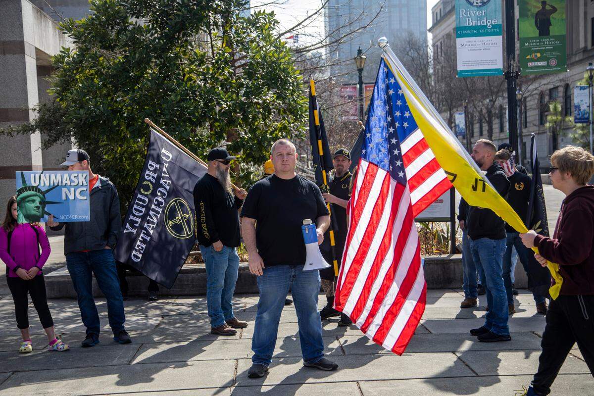 About 40 demonstrators including about a dozen men in Proud Boy clothing protested COVID-19 mandates on Jones Street Friday, Feb. 25, 2022. Some of the demonstrators arrived in a convoy that included a tractor-trailer and was part of an earlier protest in Mebane that was advertised on social media as a trucker convoy.