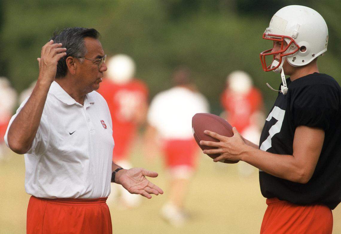 N.C. State starting quarterback Philip Rivers (17) listens to offensive coordinator/quarterback coach Norm Chow during drill at practice in 2000.