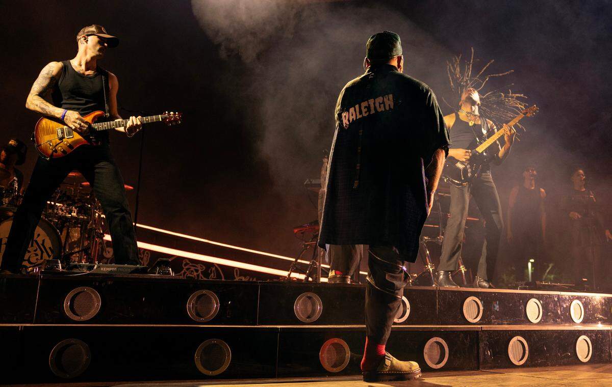 Teddy Swims wearing a cape with “Raleigh” on the back, builds the energy with his band in concert at Raleigh, N.C.’s Red Hat Amphitheater.