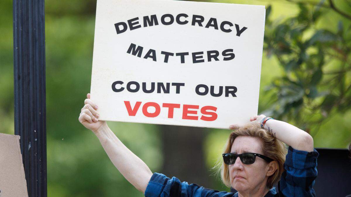 Patryce Britton holds a sign during a rally on Monday, April 14, 2025, in Raleigh, N.C., held in protest of Republican state Supreme Court candidate Jefferson Griffin’s challenge of 65,000 votes in the November election.