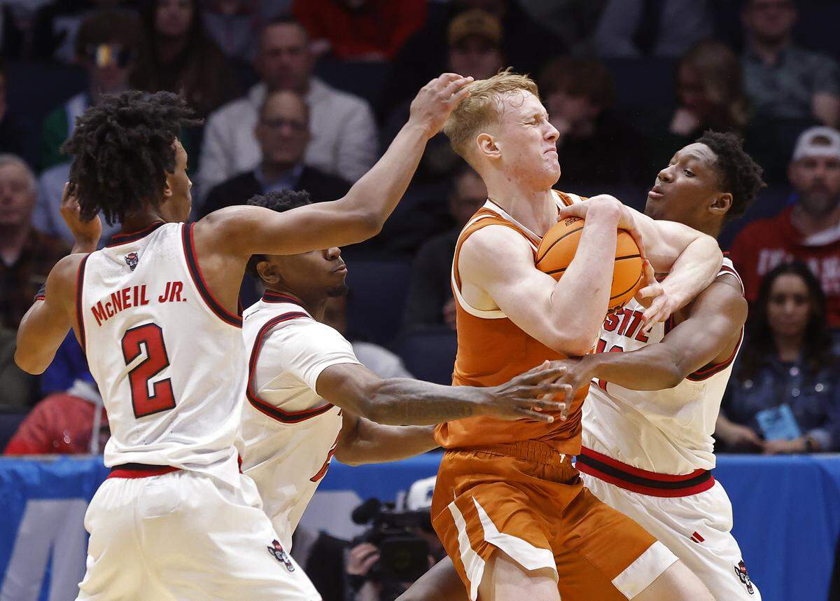 N.C. State’s Paul McNeil Jr., Terrance Arceneuax and Musa Sagnia pressure Texas’ Matas Vokietaitis during the first half of the Wolfpack’s game during the NCAA First Four on Tuesday, March 17, 2026, at the University of Dayton Arena in Dayton, Ohio. 