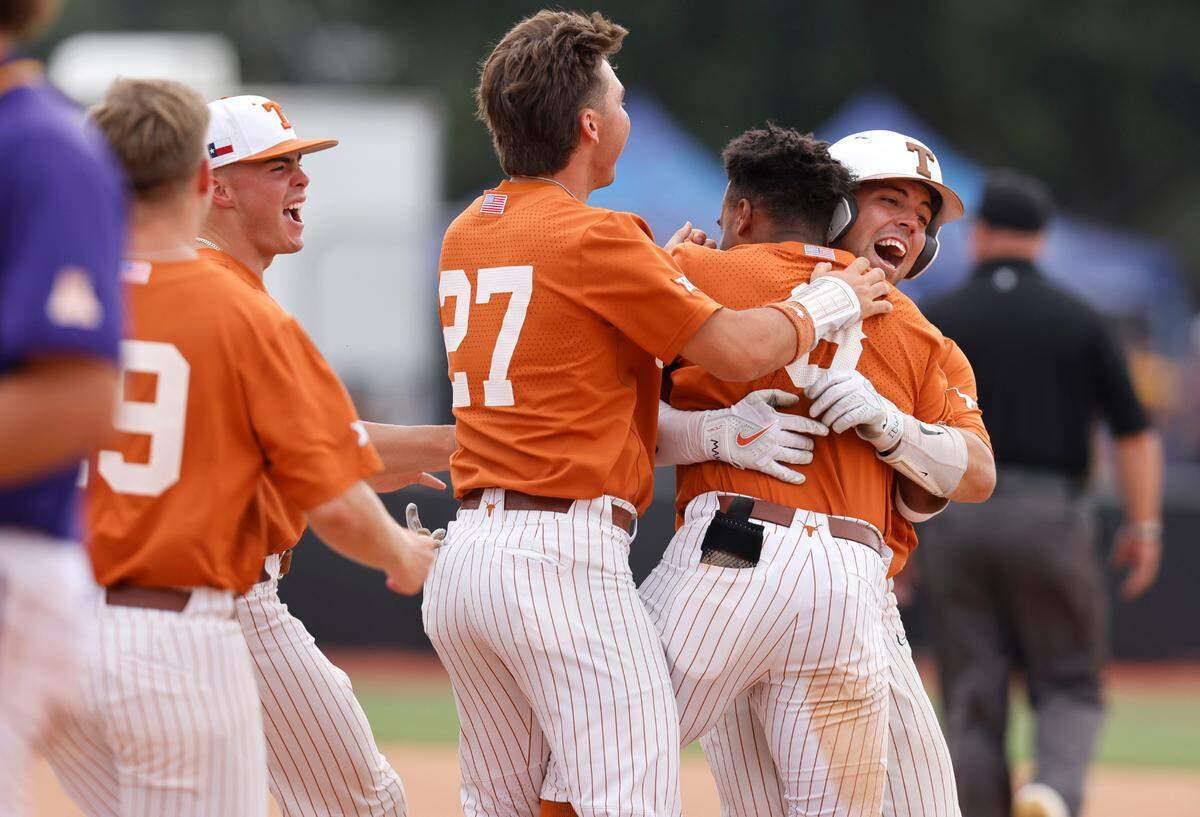 Texas players celebrate with Texas’ Dylan Campbell (8) after Campbell hit a RBI single in the ninth inning to give Texas a 9-8 victory over ECU in the Greenville Super Regional at Clark-LeClair Stadium Saturday, June 11, 2022.