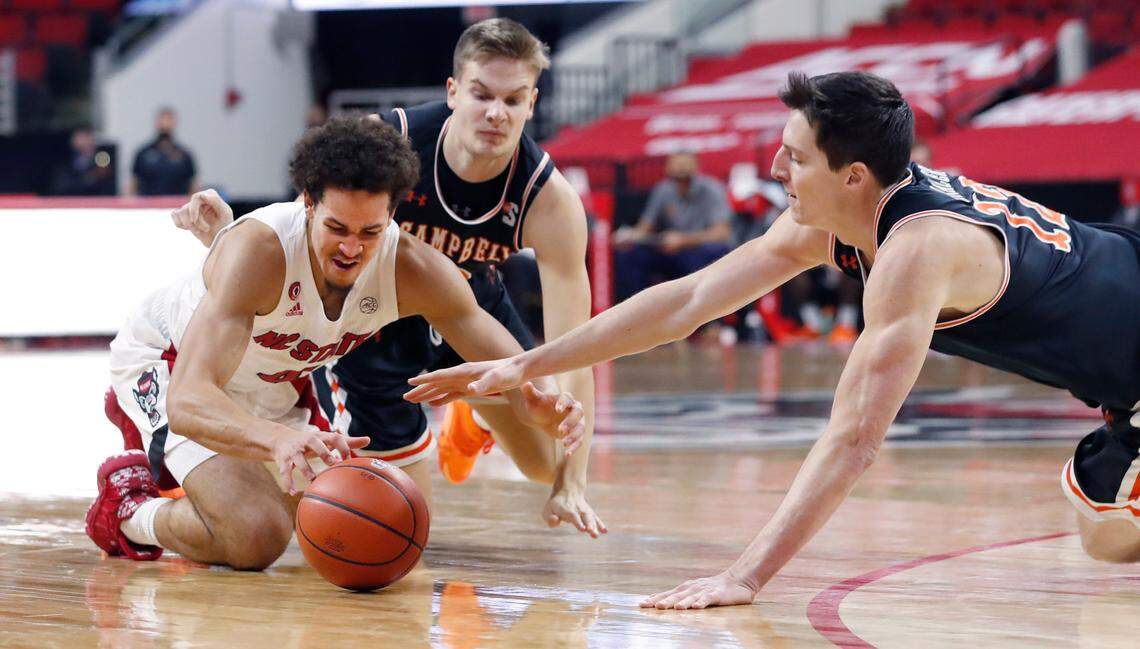 Campbell’s Gediminas Mokseckas (0) and Jesus Carralero (12), right, go after the loose ball with N.C. State’s Jericole Hellems (4) during the first half of N.C. State’s game against Campbell at PNC Arena in Raleigh, N.C., Saturday, Dec. 19, 2020.