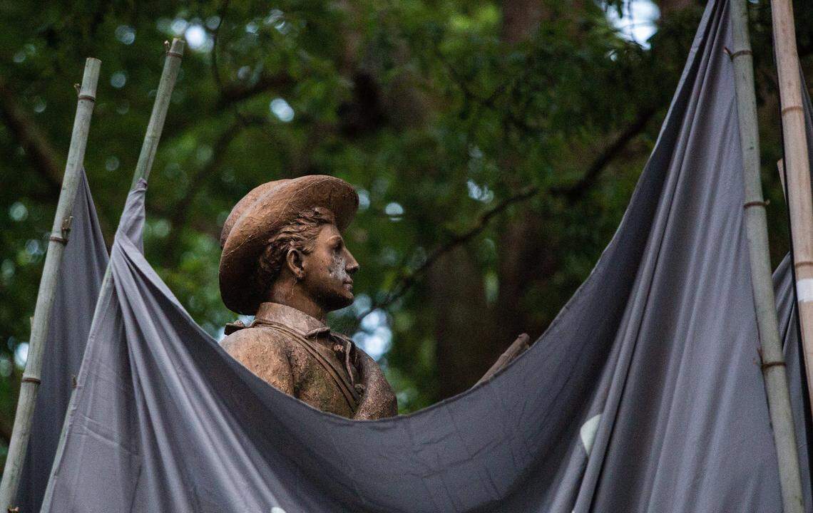 Demonstrators obscure a Confederate statue known as Silent Sam with large banners Monday, August 20, 2018 at UNC-Chapel Hill before toppling it.