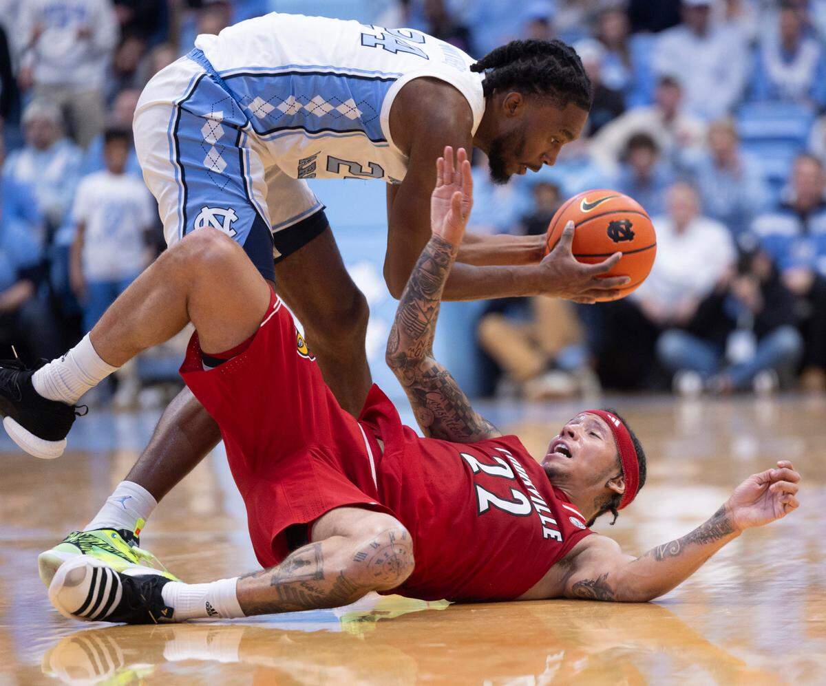North Carolina’s Jae’Lyn Withers (24) recovers a loose ball over Louisville’s Tre White (22) in the second half on Wednesday, January 17, 2024 at the Smith Center in. Chapel Hill, N.C.