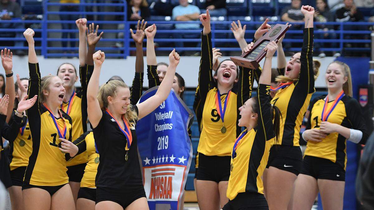 Chapel Hill players celebrate after receiving the trophy for winning the state championship. The Chapel Hill Tigers defeated the West Henderson Falcons 26-28, 25-20, 25-23 and 25-11 in a high school volleyball match for the NCHSAA 3A championship on November 9, 2019.