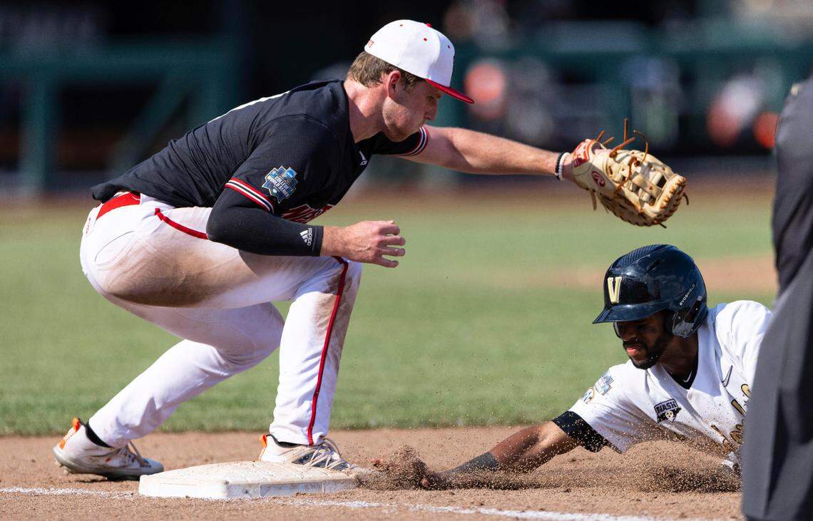 Vanderbilt’s Javier Vaz, right, dives safely back into first base ahead of the tag from North Carolina State’s Sam Highfill in the ninth inning during a baseball game in the College World Series, Friday, June 25, 2021, at TD Ameritrade Park in Omaha.