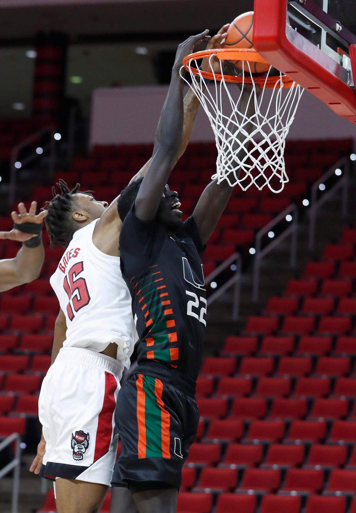 N.C. State’s Manny Bates (15) blocks the shot by Miami’s Deng Gak (22) during the first half of N.C. State’s game against Miami at PNC Arena in Raleigh, N.C., Saturday, January 9, 2021.