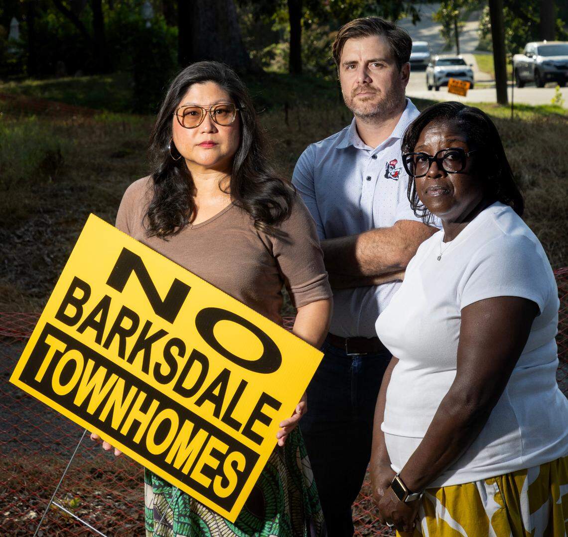 Ann Sun, Daniel McCoy and Edith Neal pose next to 528 Barksdale Drive in the Woodcrest neighborhood of Raleigh Monday, August 26, 2024. The existing home at 528 Barksdale has been torn down and new townhomes are planned at the site.