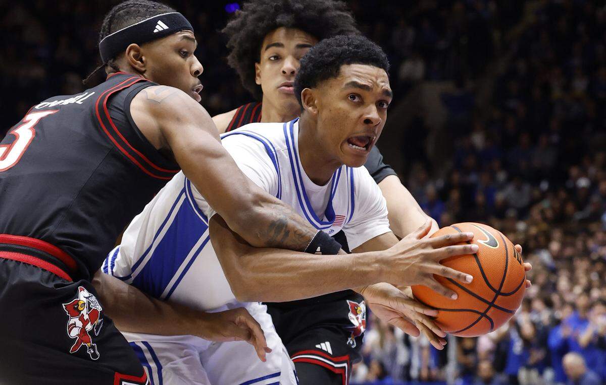 Duke’s Caleb Foster (1) drives through the defense of Louisville's Ryan Conwell (3) and Mikel Brown Jr. (0) during the first half of Duke’s game against Louisville at Cameron Indoor Stadium in Durham, N.C., Monday, Jan. 26, 2026.