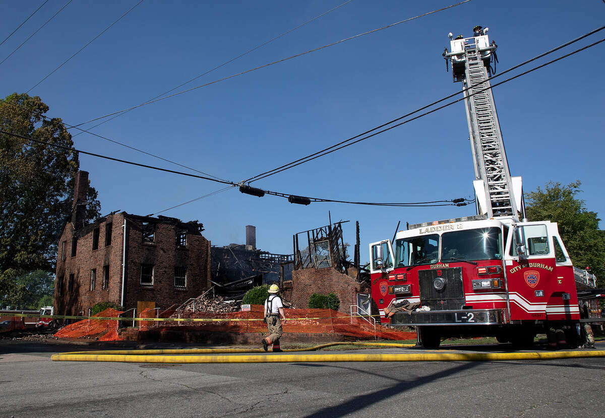 Firefighters work the scene of a fire at a building near the intersection of East Main Street and Holman Street on Thursday, May 2, 2024, in Durham, N.C.