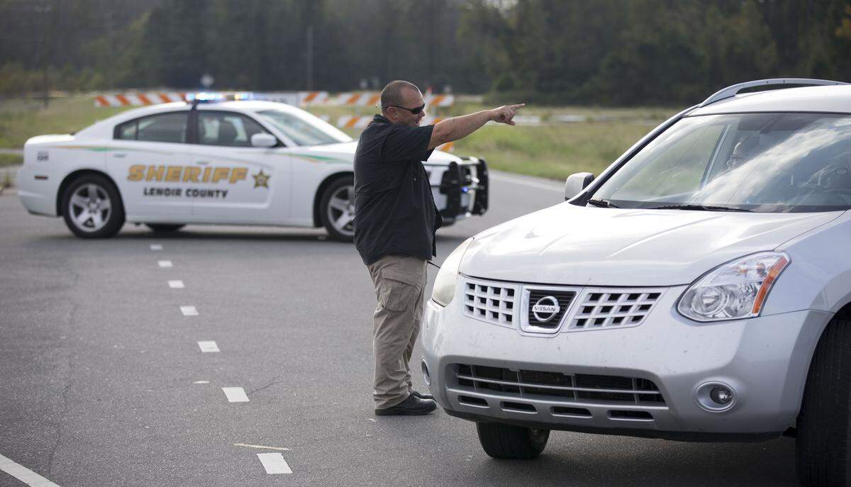A Lenoir County deputy diverts traffic off of NC 55 east of Kinston after closing the road due to the rising level of the Neuse River on Thursday afternoon September 20, 2018. Heavy rain from Hurricane Florence in the west has brought the Neuse River to new flood levels forcing officials to close the road.