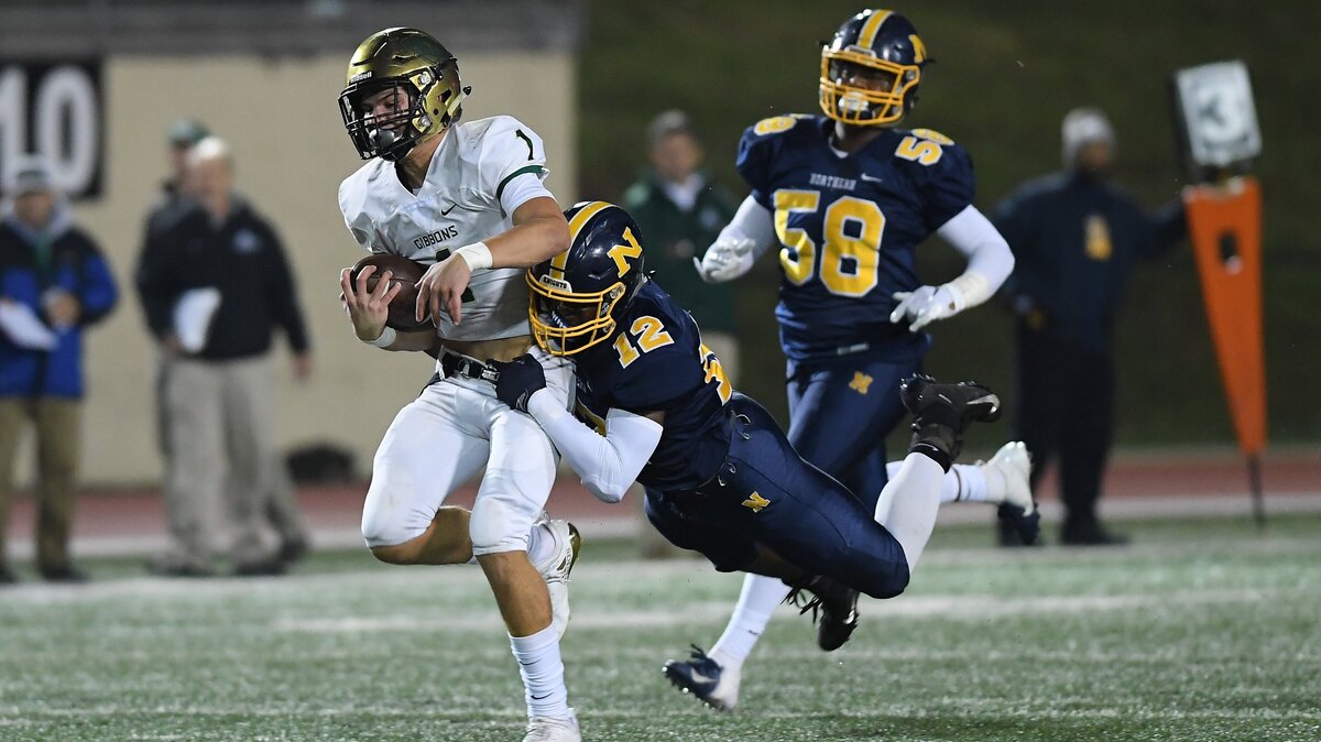 Ethan Hebb (1) of Cardinal Gibbons carries the ball against Anthony Freeman (12) and Justin Rhodes (58) of Northern Durham. The Cardinal Gibbons Crusaders visited the Northern Durham Knights in a high school football game on November 9, 2018.