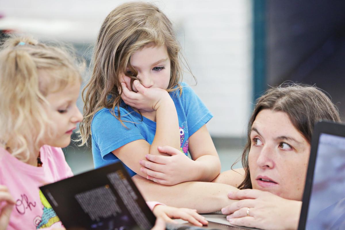 Cora May Baird, 5, left, and Cosi Everett, 6, look over a book with Everett’s mother, Megan, right, during the weekly Homeschool Explorers meeting for students and parents at Method Community Center in Raleigh on Tuesday, Nov. 27, 2018.