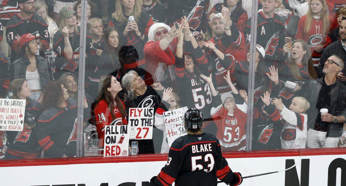 Fans go after a puck thrown into the crowd by Carolina's Jackson Blake (53) before the Hurricanes’ game against the Golden Knights in the first game of the Stanley Cup Final at the Lenovo Center in Raleigh, N.C., Tuesday, June 2, 2026.