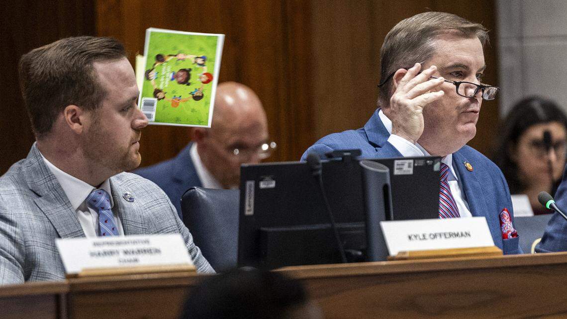N.C. House Majority Leader Brenden Jones tosses a book he finds offensive over his shoulder while questioning Chapel Hill-Carrboro City Schools Superintendent Rodney Trice and School Board Chair George Griffin during a sometimes tense House committee hearing on Wednesday, Dec. 10, 2025, in the Legislative Building auditorium in Raleigh. During the hearing, Jones cited and tossed several children’s books from a third-party list that had previously appeared on the district’s website.