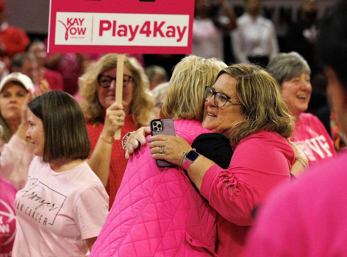 People embrace at the conclusion of a ceremony to honor survivors of cancer during halftime of N.C. State’s Play4Kay Game on Monday, Feb. 5, 2024, at Reynolds Coliseum in Raleigh, N.C.