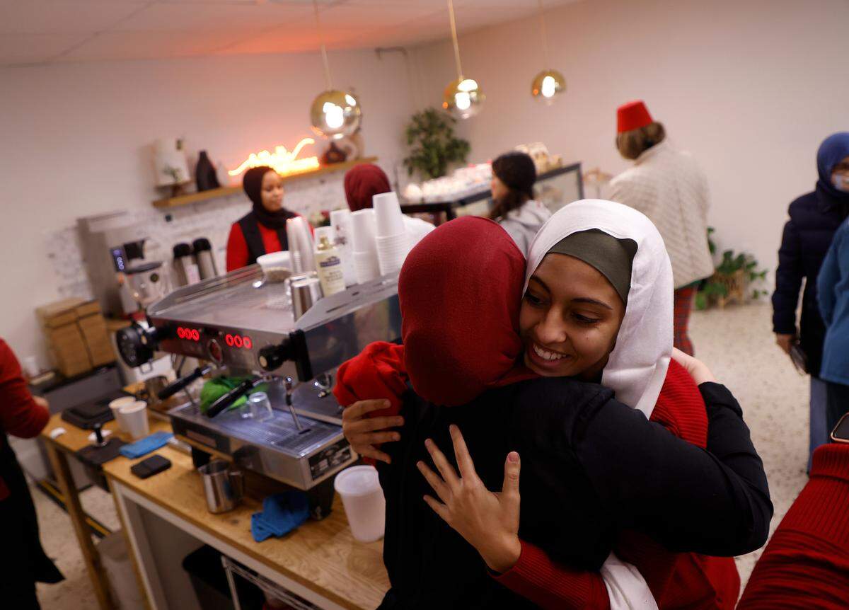 Reem Kounidry, right, is greeted with a hug as community members gather to watch the World Cup semifinal match between Morocco and France at La Recette patisserie in Durham, N.C. on Wednesday, Dec. 14, 2022.