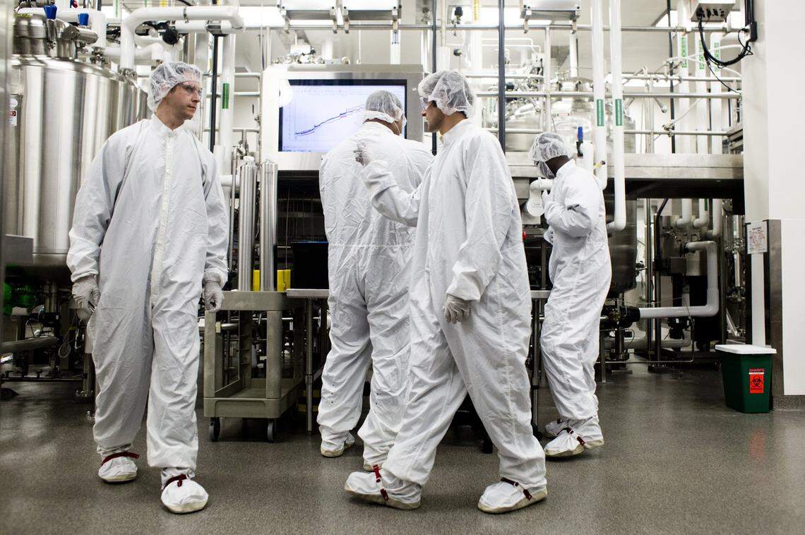 From left, Shane Bigler, Gerg Worsley, Mike Principato and Kofi Duah work inside a lab used to produce cell cultures Wednesday, April 14, 2014 at Biogen Idec in Research Triangle Park, Durham, N.C. Biogen Idec is the manufacturer of Avonex, a drug for the treatment of multiple sclerosis.
