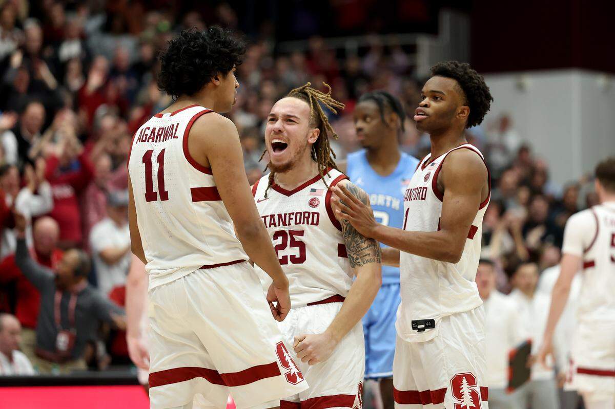 Stanford’s Jeremy Dent-Smith (25) and Ebuka Okorie (1) congratulate teammate Ryan Agarwal (11) after he made a 3-pointer against North Carolina in the final minute of the game at Stanford Maples Pavilion on January 14, 2026 in Palo Alto, California.