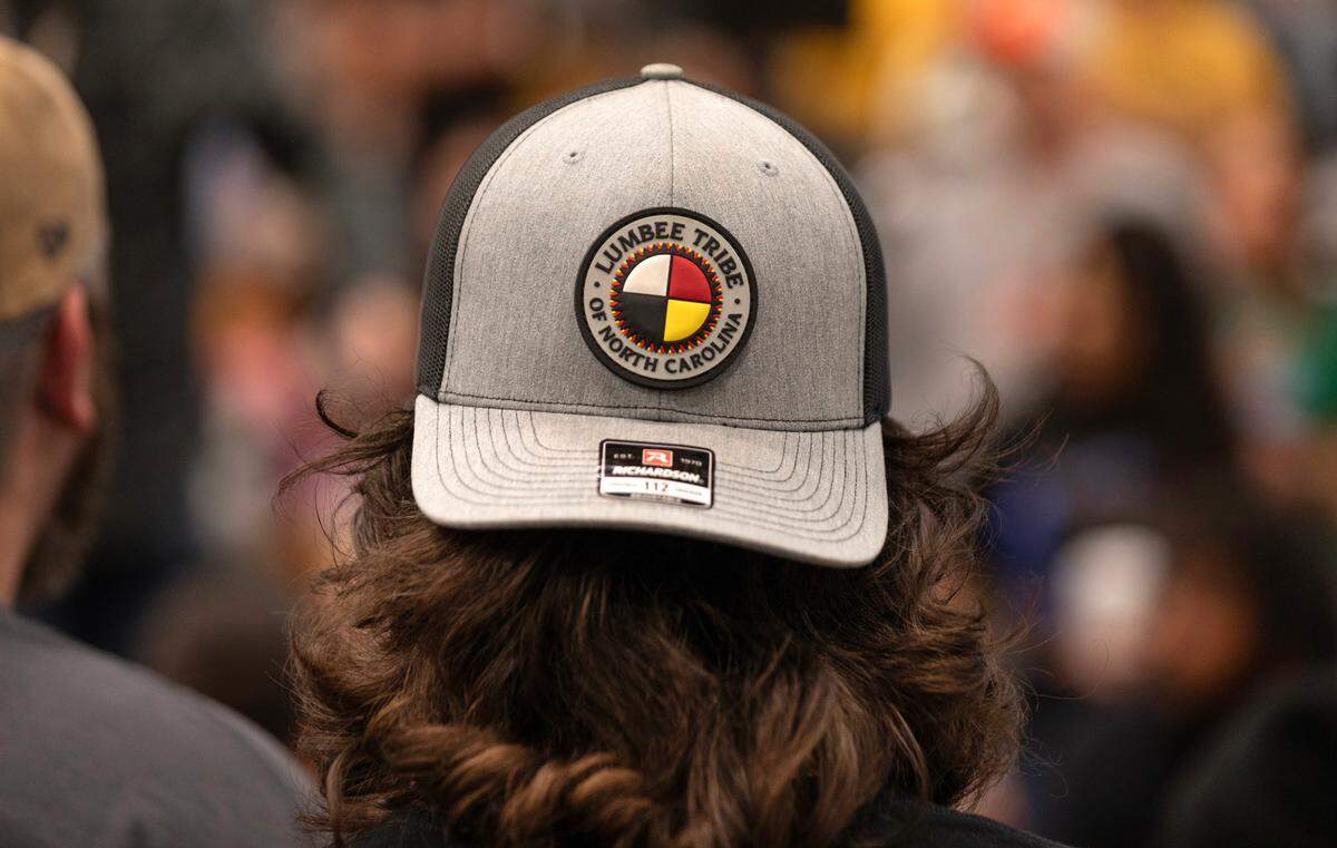 A spectator at the Bravenation Powwow and Gathering at Pembroke at UNC-Pembroke wears a hat showing the logo of the Lumbee.
