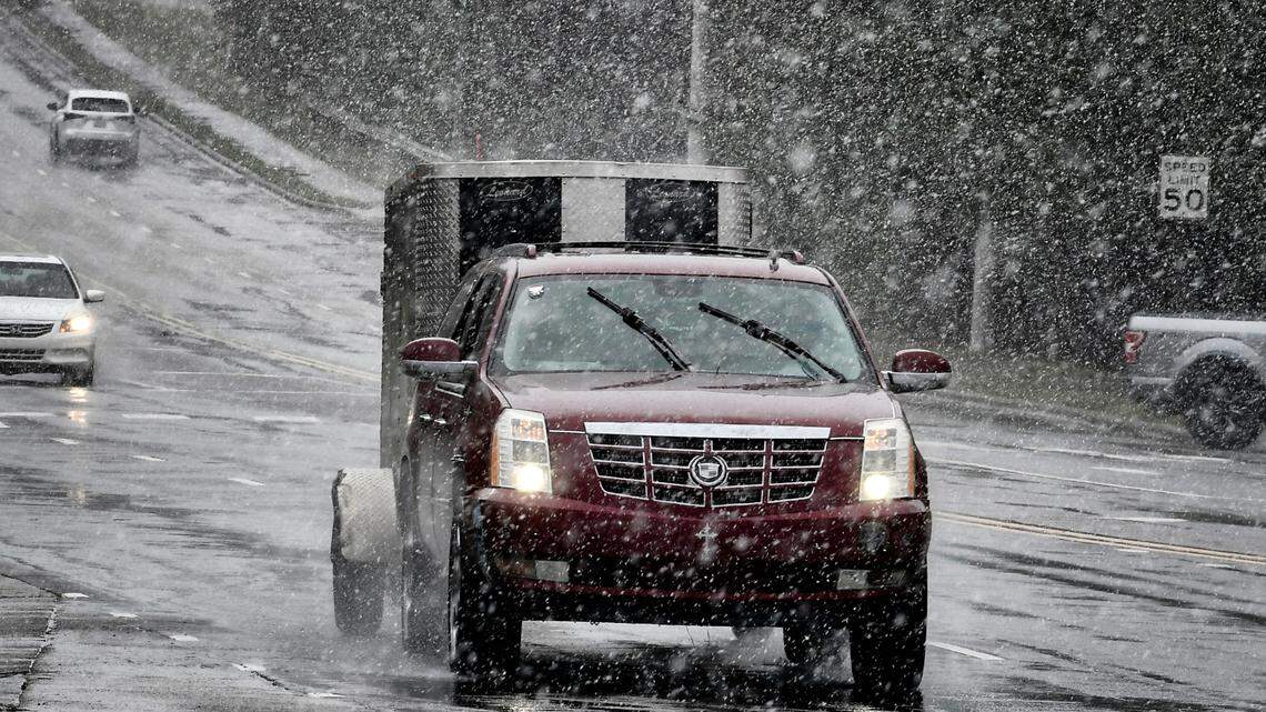 Snow falls on traffic along Highway 55 in Cary, N.C. as a winter storm moves into the area, Monday morning, Jan. 3, 2022.