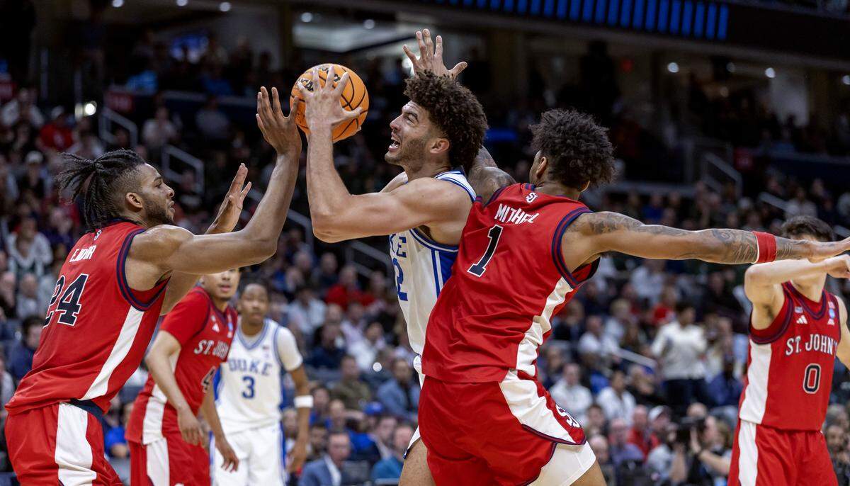 Duke forward Cameron Boozer (12) puts up a shot against St. John’s forwards Zuby Ejiofor (24) and Dillon Mitchell (1) in the first half during the Sweet Sixteen of the NCAA Tournament on Friday, March 27, 2026, at Capital One Arena in Washington, D.C.