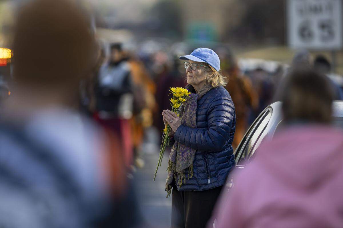 People meditate as a group of Buddhist Monks from Texas pass them along US 421 in Chatham County during the Walk for Peace on Wednesday, January 21, 2026.
