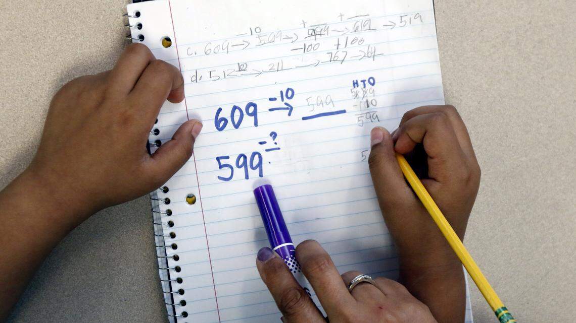 A teacher works with a 2nd grader learning subtraction.