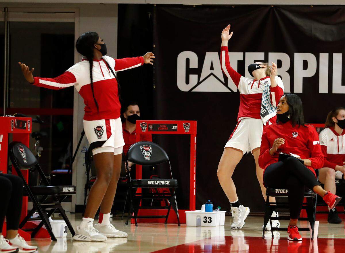 N.C. State’s Jada Rice, left, and N.C. State’s Elissa Cunane celebrate a three-pointer by Kai Crutchfield during the second half of N.C. State’s 83-53 victory over Pittsburgh at Reynolds Coliseum in Raleigh, N.C., Thursday, February 25, 2021.