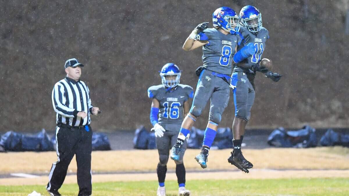Chance Smith (11) of Wake Forest celebrates an interception along his teammate Devon Grant (8). The Leesville Road Pride visited the Wake Forest Cougars in a high school football game on November 30, 2018. Wake Forest won 41-10.