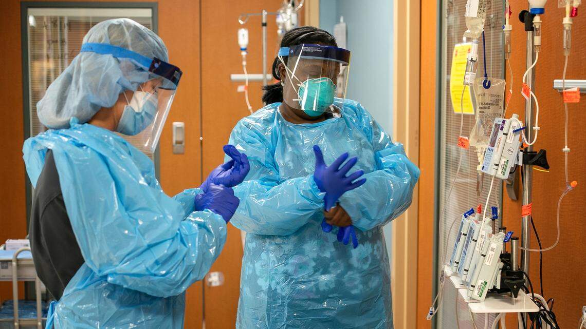 Certified Nursing Assistants Attilah Dunn, left, and Leanna Parker don protective equipment as they make their rounds working with COVID-19 patients in the ICU at Johnston UNC Health Care on Thursday, August 19. 2021 in Clayton, N.C.