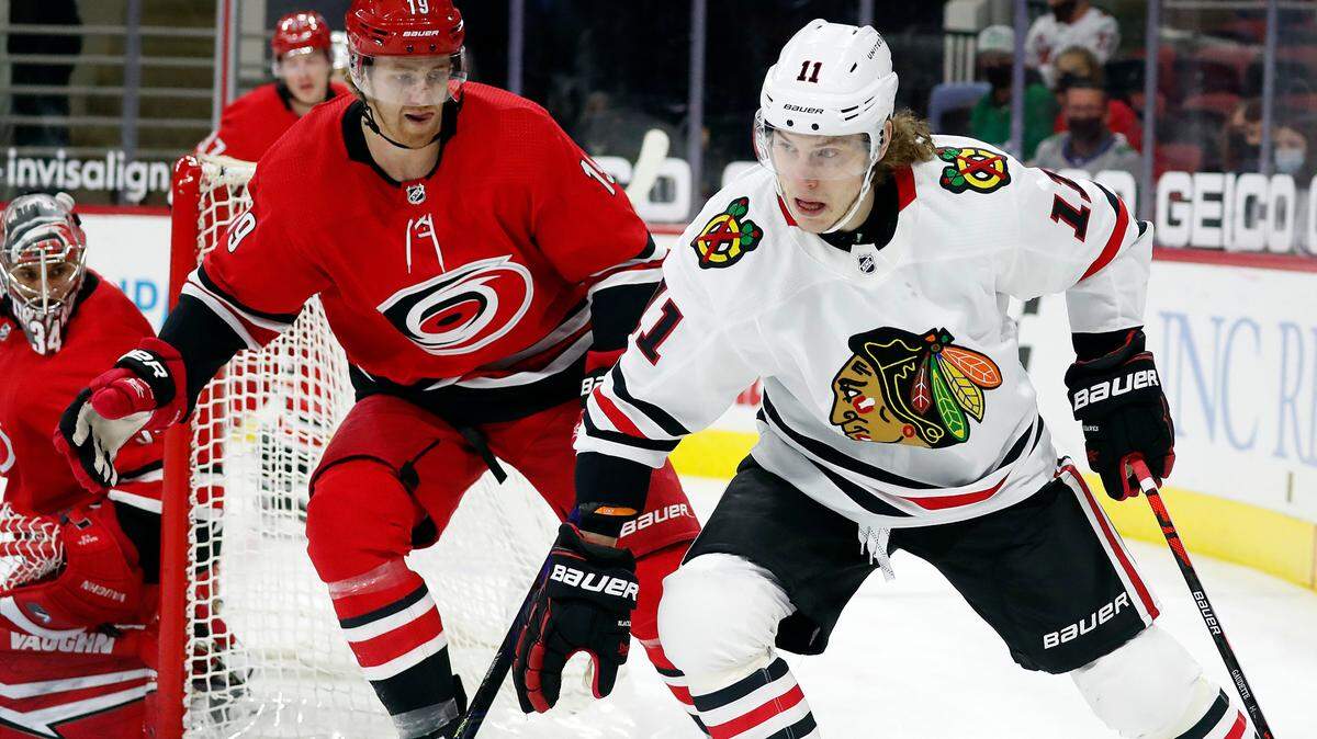 Chicago Blackhawks’ Adam Gaudette (11) drives the puck around Carolina Hurricanes’ Dougie Hamilton (19) during the first period of an NHL hockey game in Raleigh, N.C., Thursday, May 6, 2021. (AP Photo/Karl B DeBlaker)