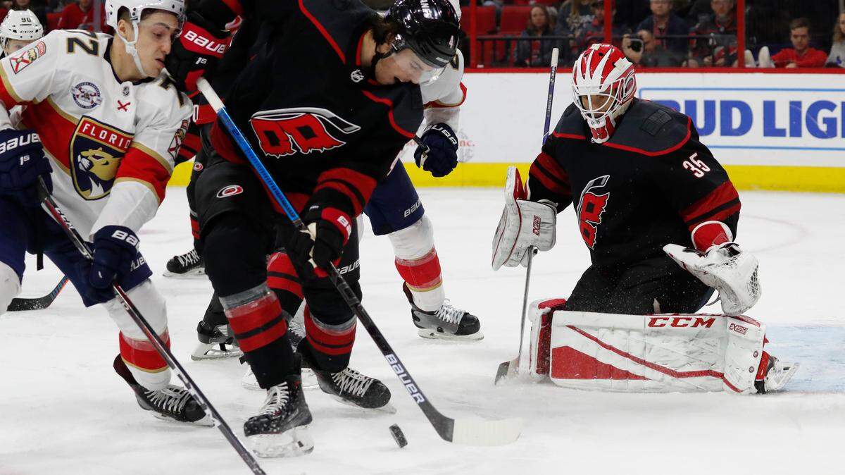 Carolina Hurricanes’ Haydn Fleury (4) battles Florida Panthers’ Frank Vatrano (72) in front of goaltender Curtis McElhinney (35) during the third period of an NHL hockey game, Friday, Nov. 23, 2018.