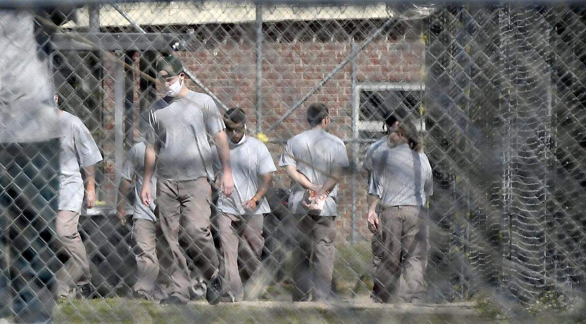 Inmates at the Neuse Correctional Institution in Goldsboro, N.C. move between buildings Sunday morning, April 19, 2020. Some are wearing masks, but incorrectly. more than 280 of 770 inmates at the Eastern North Carolina prison have tested positive for COVID-19, making it one of the hardest-hit prisons in the nation.