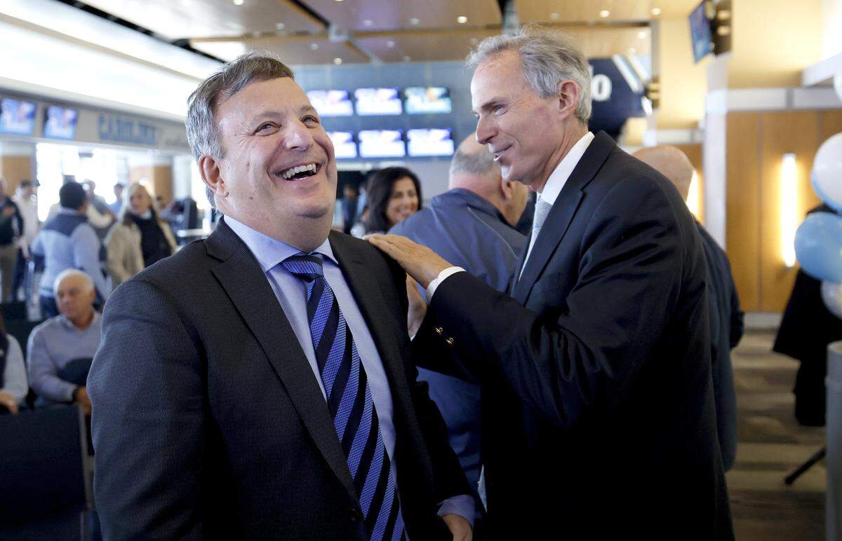 John Preyer, chair of the UNC Board of Trustees, right, laughs with Michael Lombardi, football’s new general manager, after a press conference for new North Carolina head football coach Bill Belichick at the Loudermilk Center for Excellence at UNC in Chapel Hill, N.C., Thursday, Dec. 12, 2024.