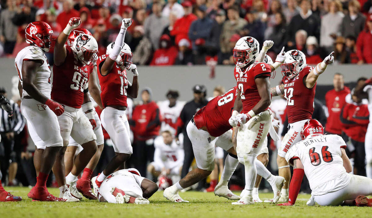 The N.C. State defense celebrates after stopping Louisville quarterback Malik Cunningham (3) on fourth down during the second half of N.C. State’s 28-13 victory over Louisville at Carter-Finley Stadium in Raleigh, N.C., Saturday, October 30, 2021.