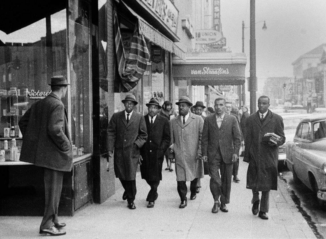 Dr. Martin Luther King, Jr. (facing camera, second from left) walks along West Main Street towards Woolworth in Durham on February 2, 1960.